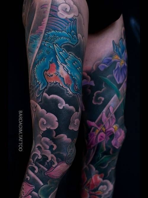 A person has a tattoo of a dragon and flowers on their leg.