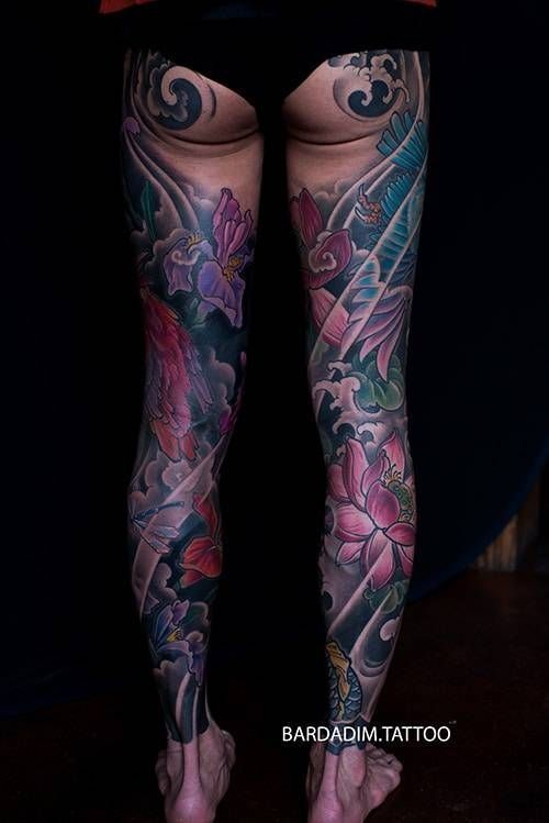 Leg tattoos with koi fish, flowers, and swirling water in color.