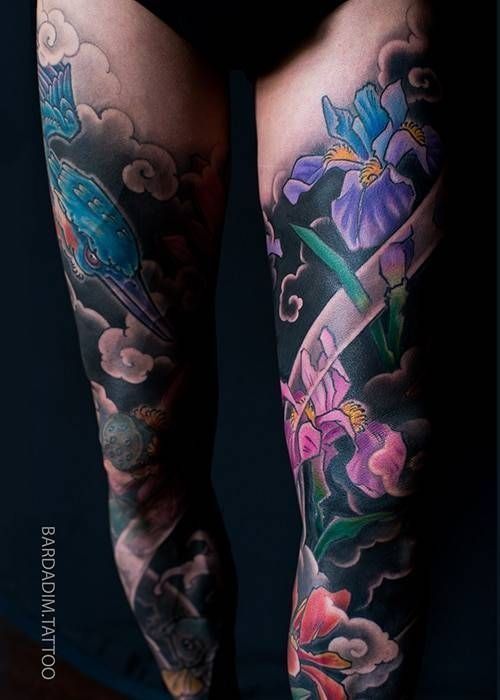 A woman has a tattoo of flowers and clouds on her leg