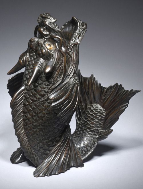 A statue of a dragon is sitting on a white surface