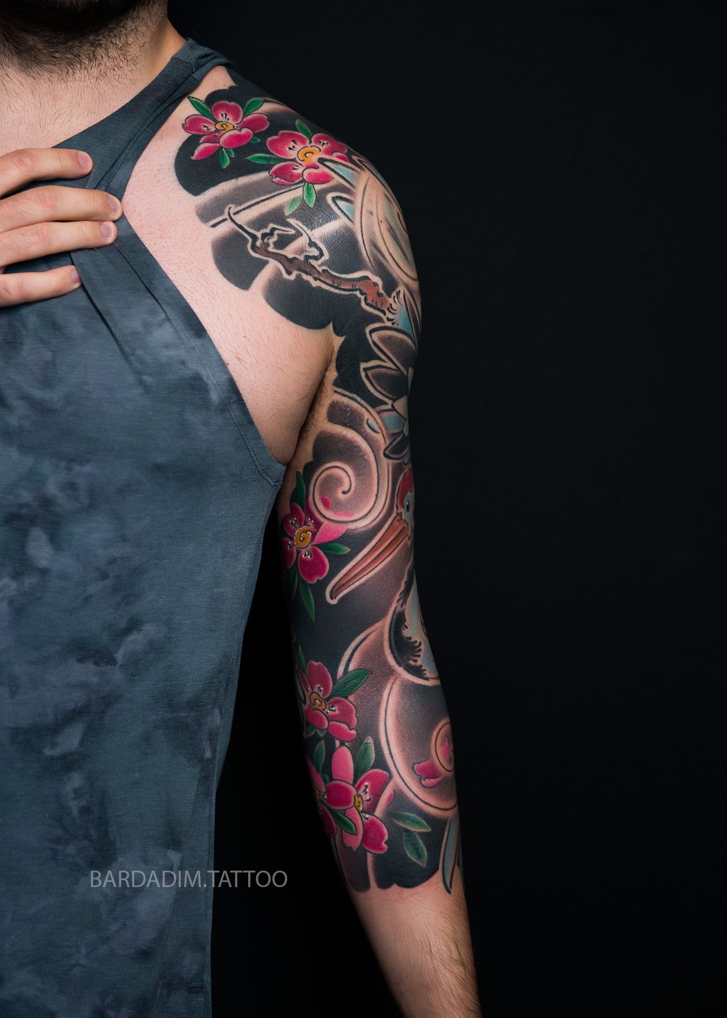 A man with a tattoo on his arm and shoulder.