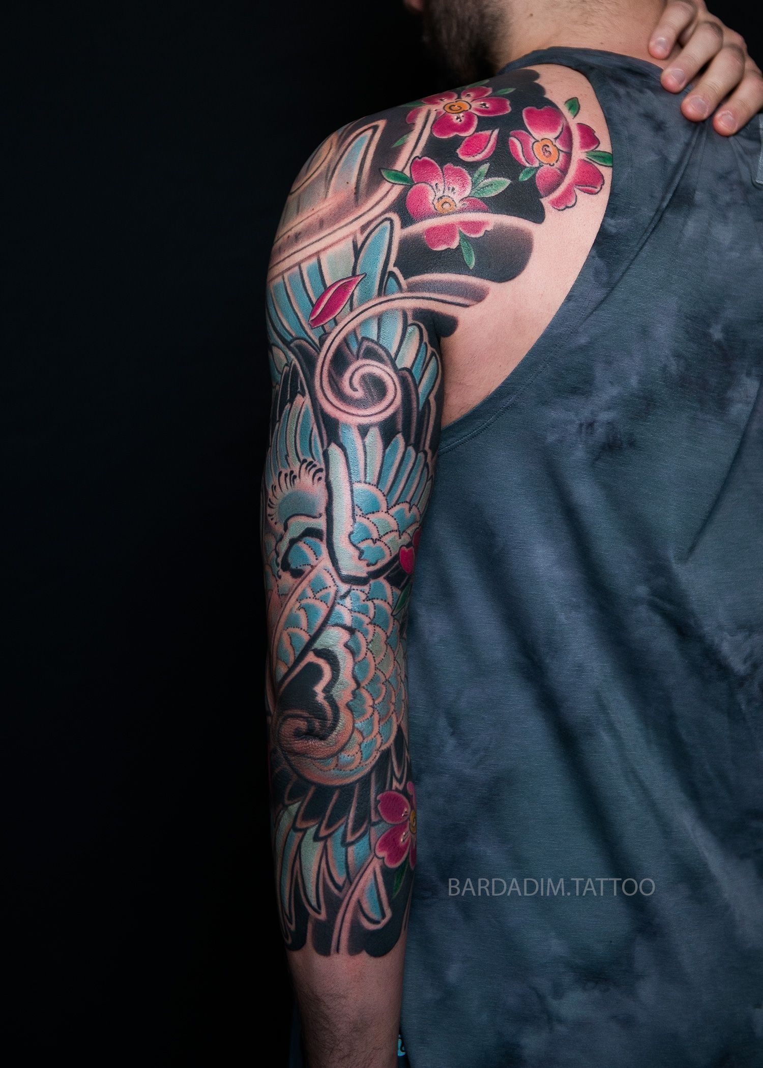 A man with a full sleeve tattoo on his arm and shoulder.