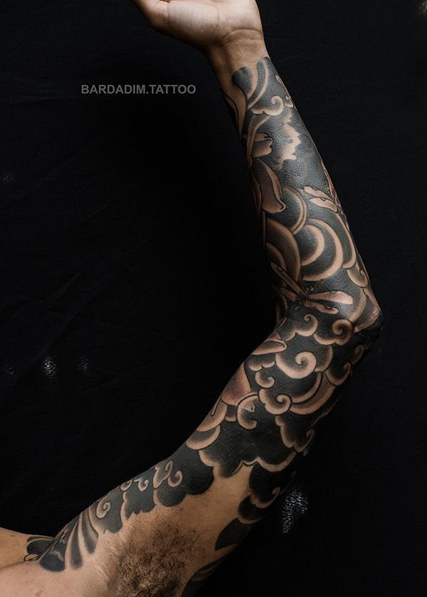 A man has a black and white tattoo on his arm.