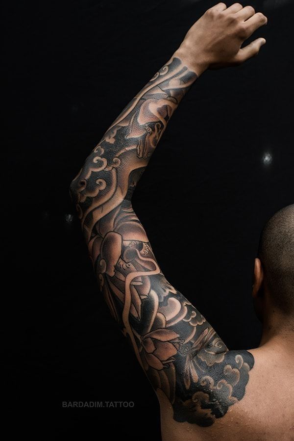 A man with a full sleeve tattoo on his arm.