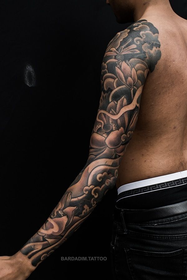 A man with a full sleeve tattoo on his arm.