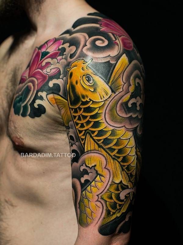 A man has a tattoo of a fish on his arm and chest.