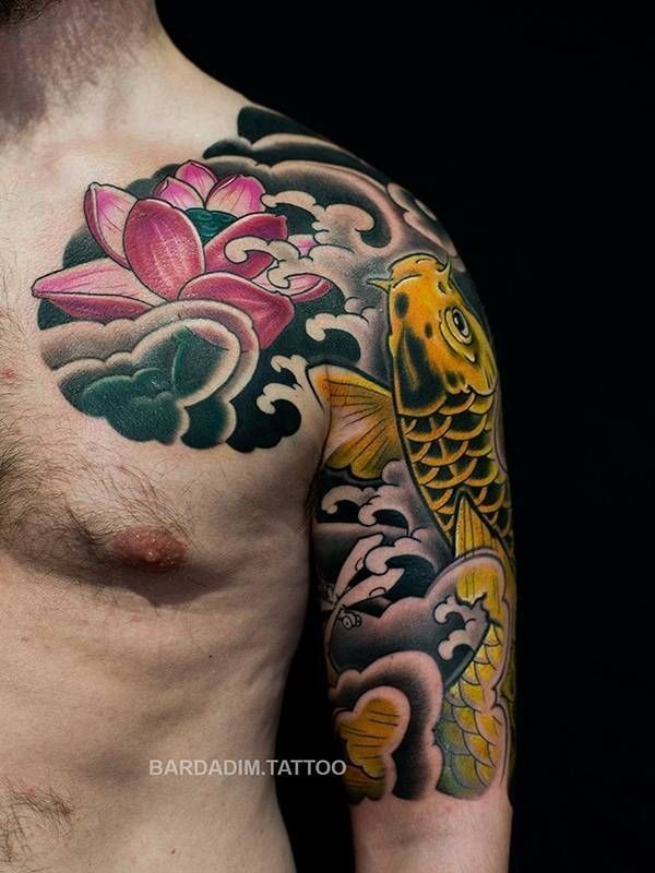 A man has a tattoo of a lotus flower and a fish on his shoulder.