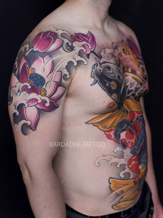 A man has a tattoo of a fish and flowers on his chest