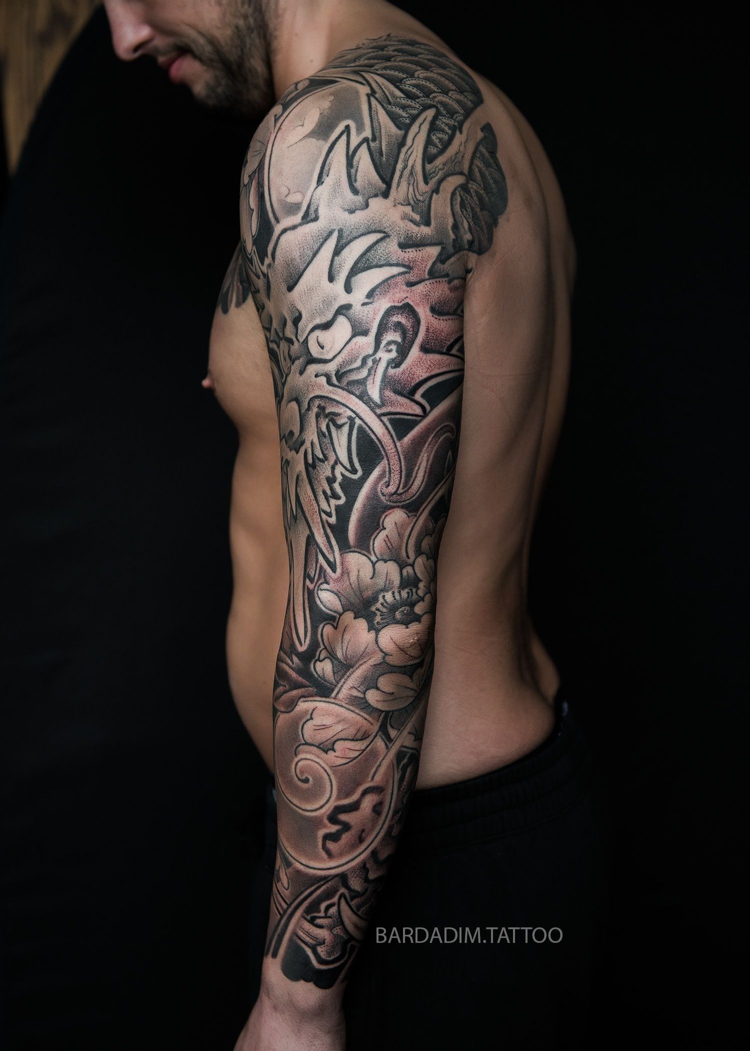 A man with a tattoo on his arm and shoulder.