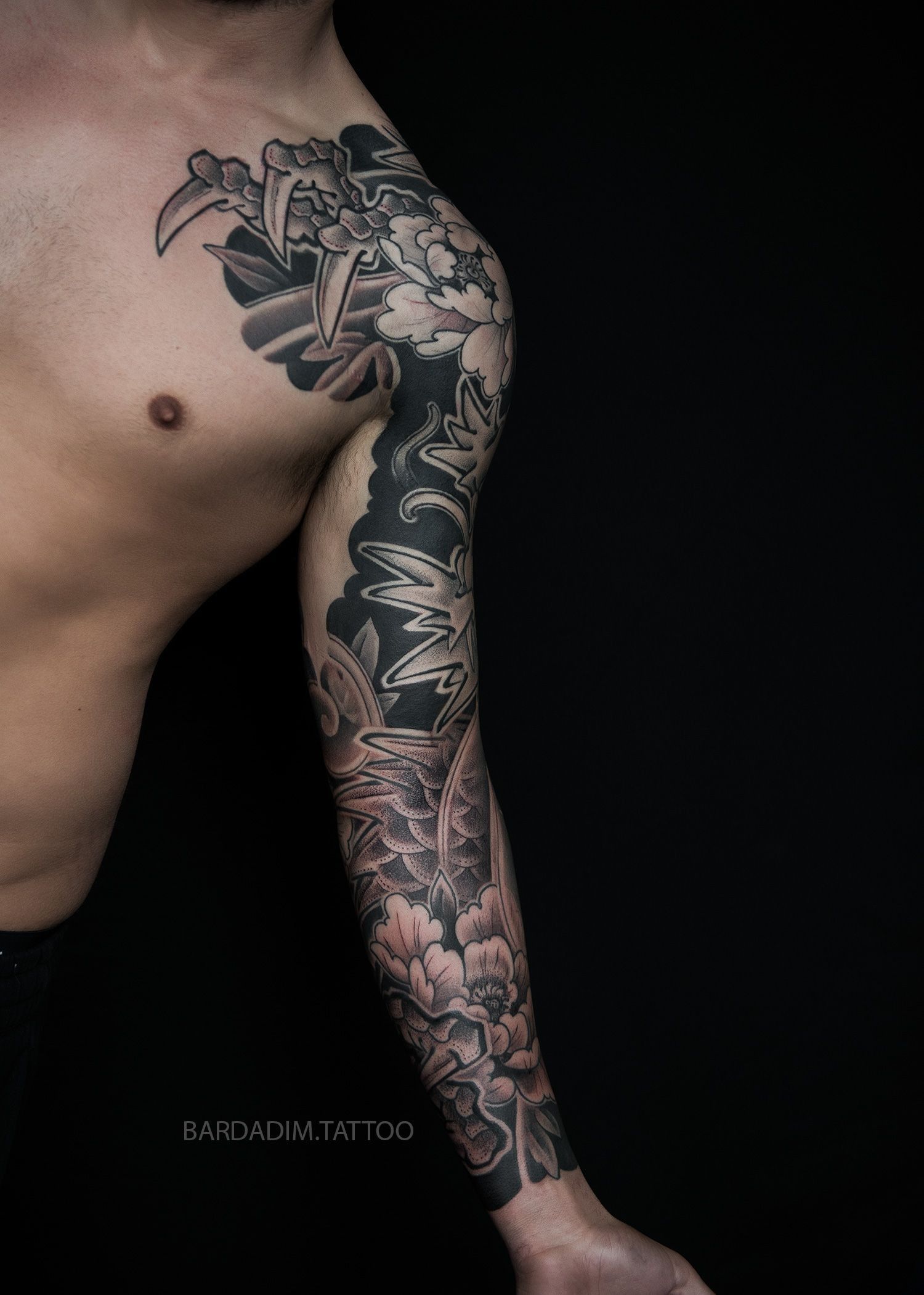A man with a tattoo on his arm and chest.