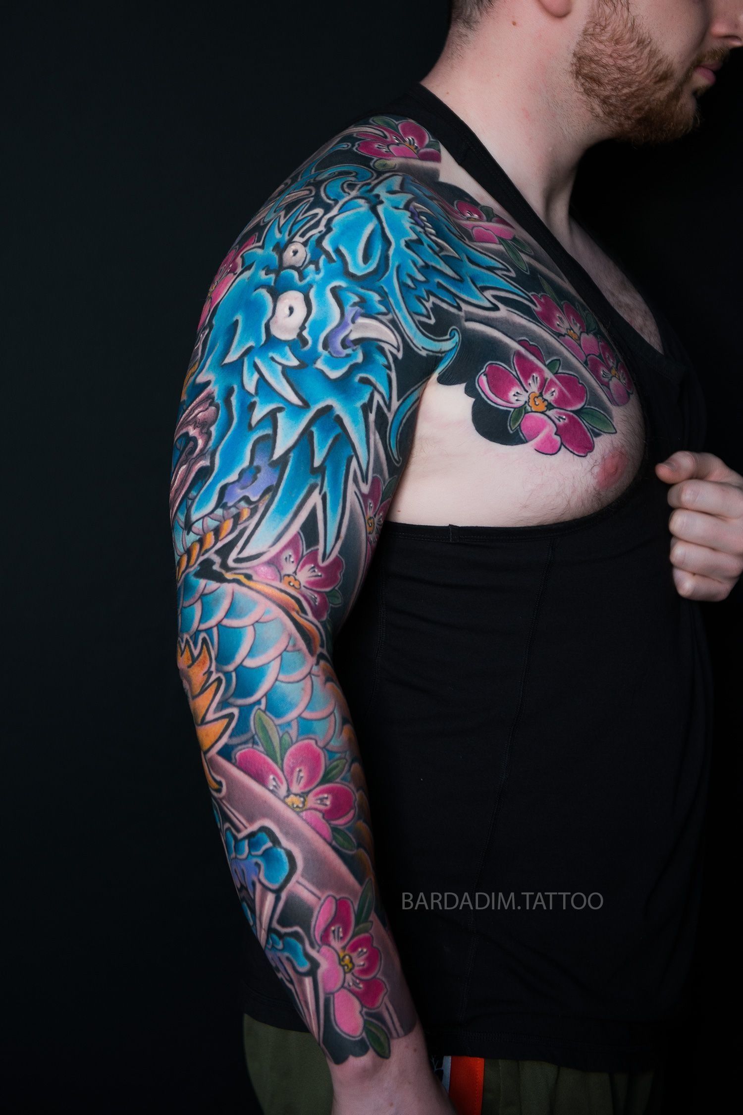 A man with a colorful tattoo on his arm and chest.