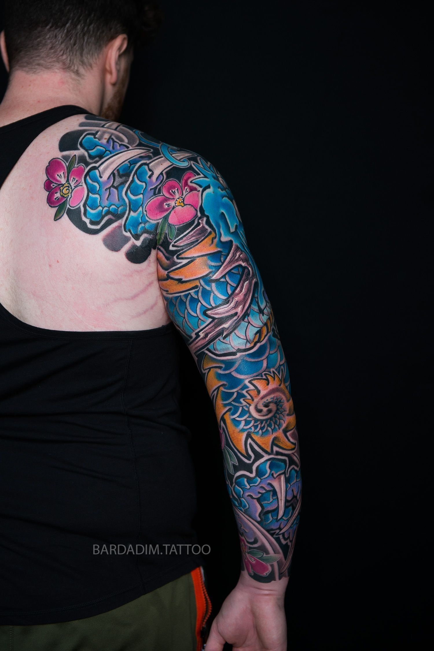 A man with a tattoo on his arm and back.