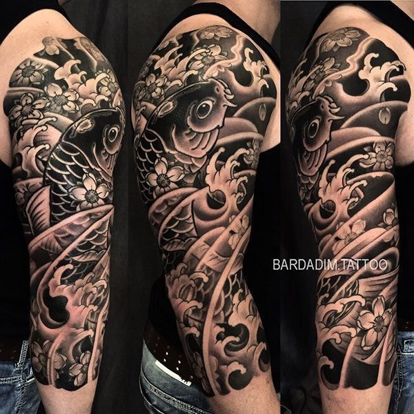 A black and white tattoo of a fish on a man 's arm