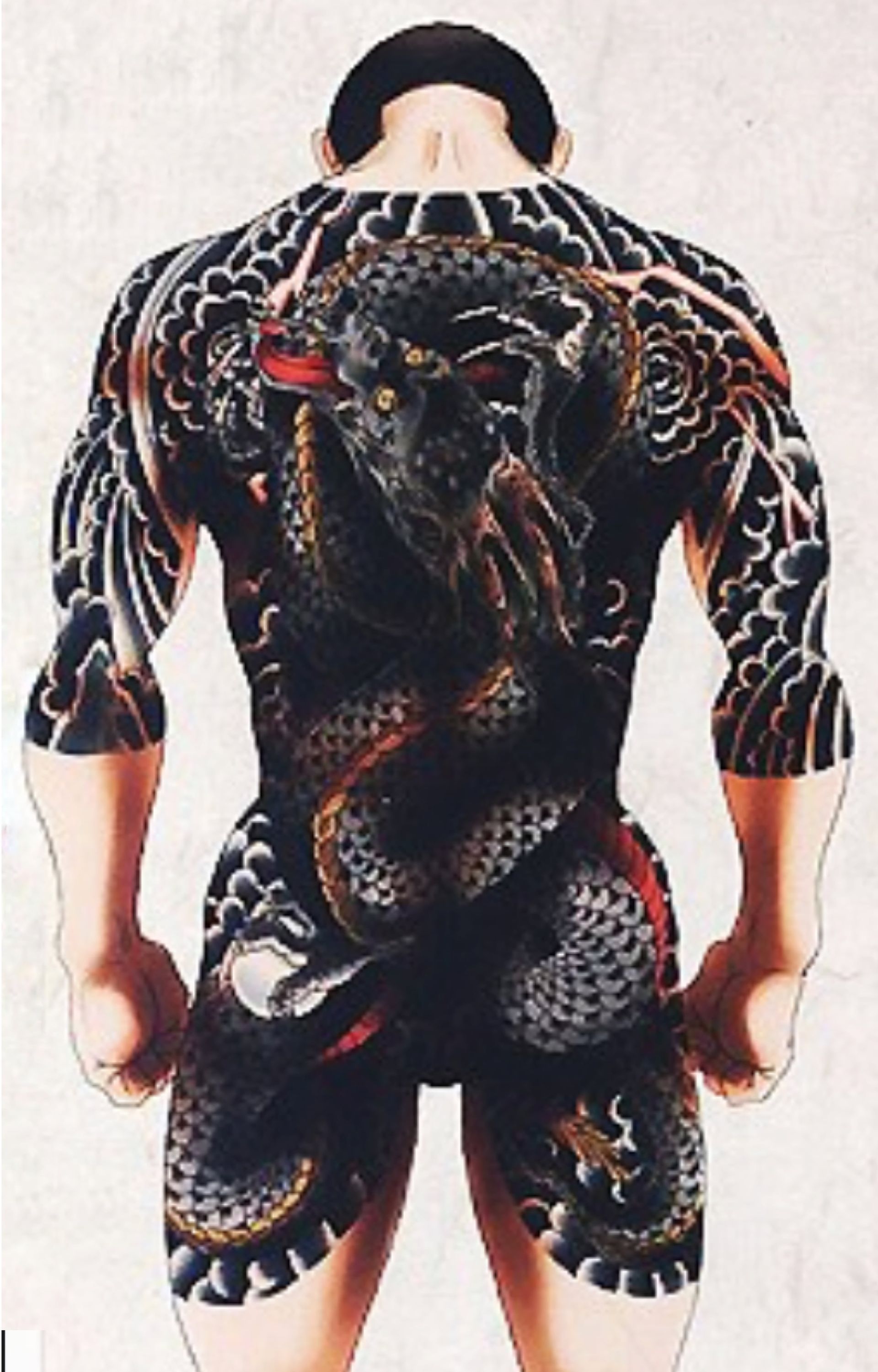 Man's back covered in traditional Japanese tattoo of a dark, serpentine dragon with red and black details.
