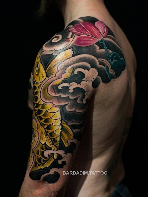 A man has a tattoo of a fish and a flower on his shoulder.