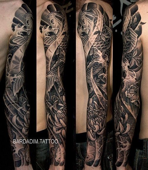 A black and white tattoo of a fish and flowers on a man 's arm.