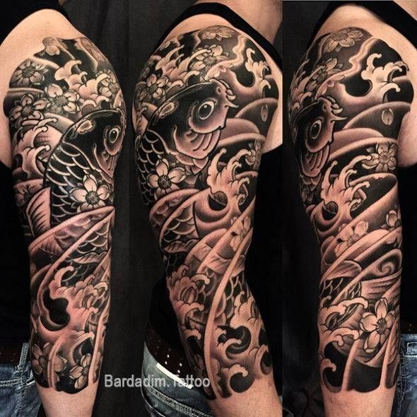 A man has a tattoo of a fish and flowers on his arm
