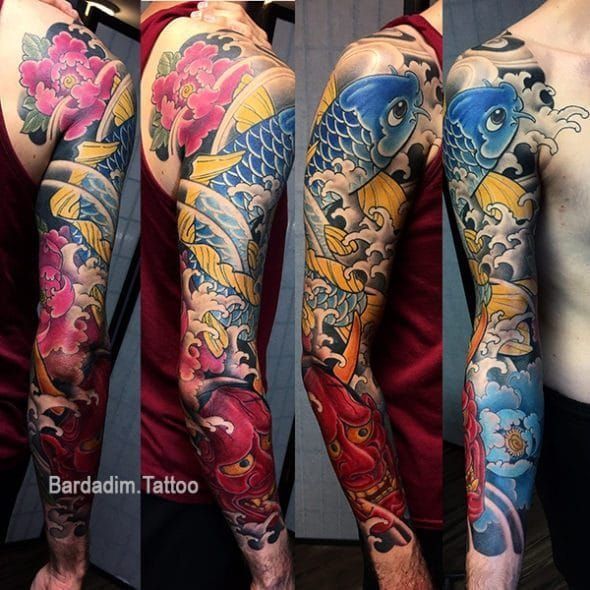 A man has a full sleeve tattoo of fish and flowers
