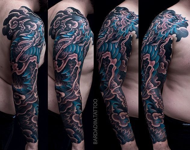 A man has a full sleeve tattoo of clouds on his arm.