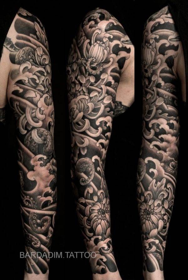 A black and white tattoo on a person 's arm and leg.