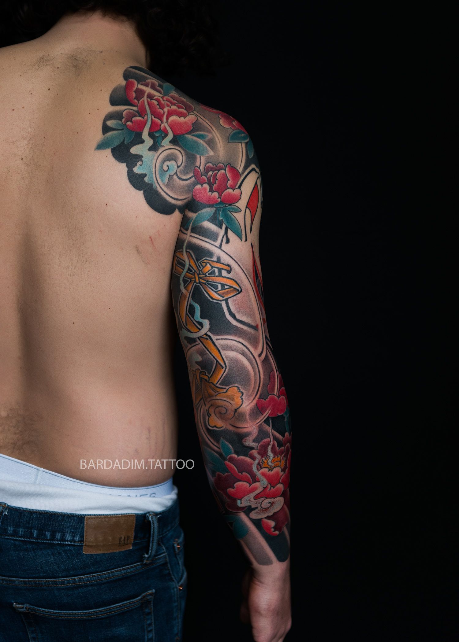 Japanese kitsune mask and peony flowers full sleeve tattoo, back view, traditional irezumi composition on male arm