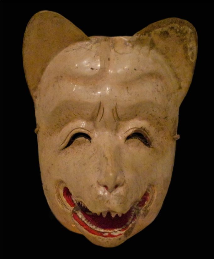 White, smiling Kitsune mask with open mouth showing red inside. Features pointy ears and closed eyes.