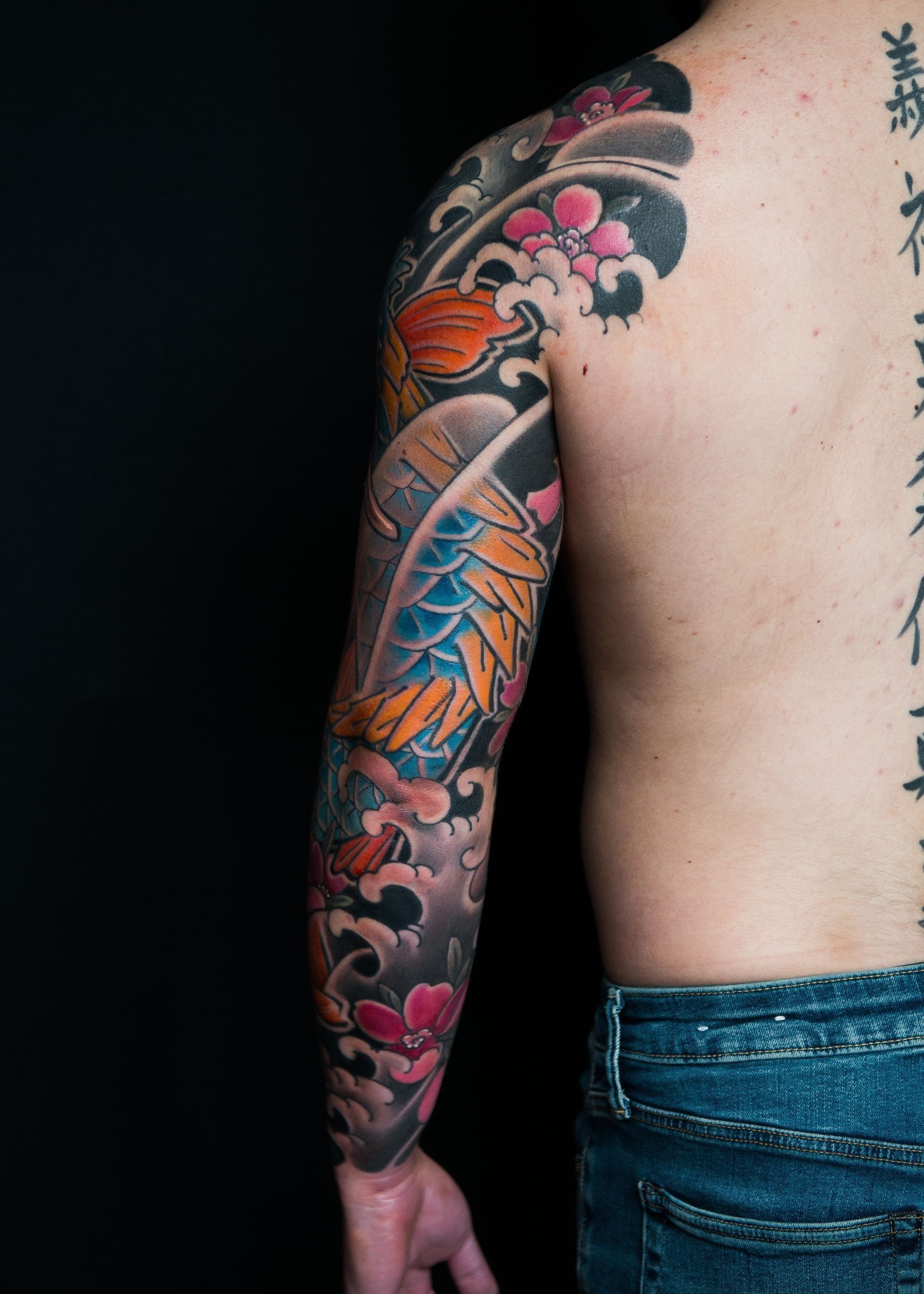 A man with a tattoo on his arm and back.