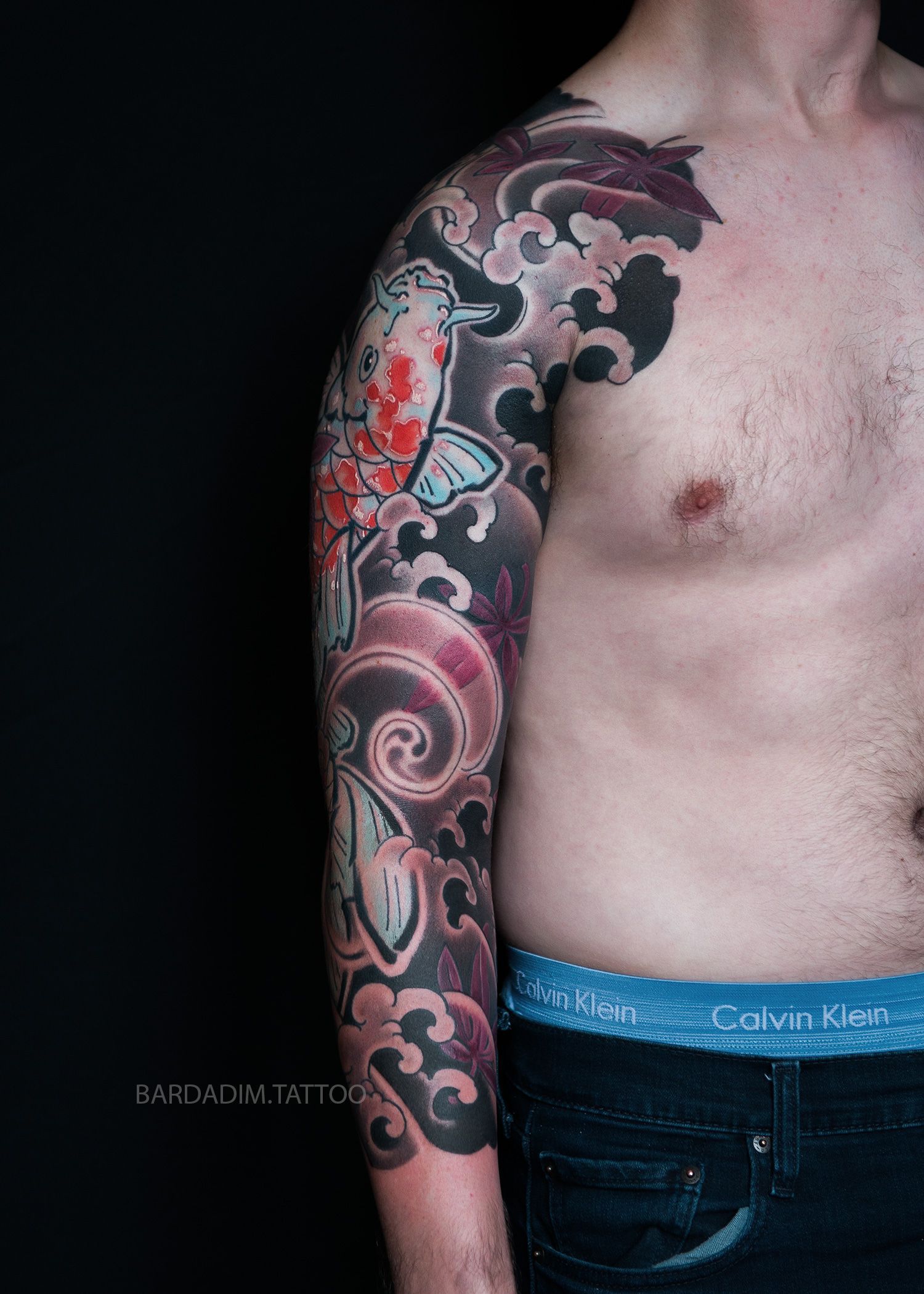 Orange koi tattoo with waves and mikiri border