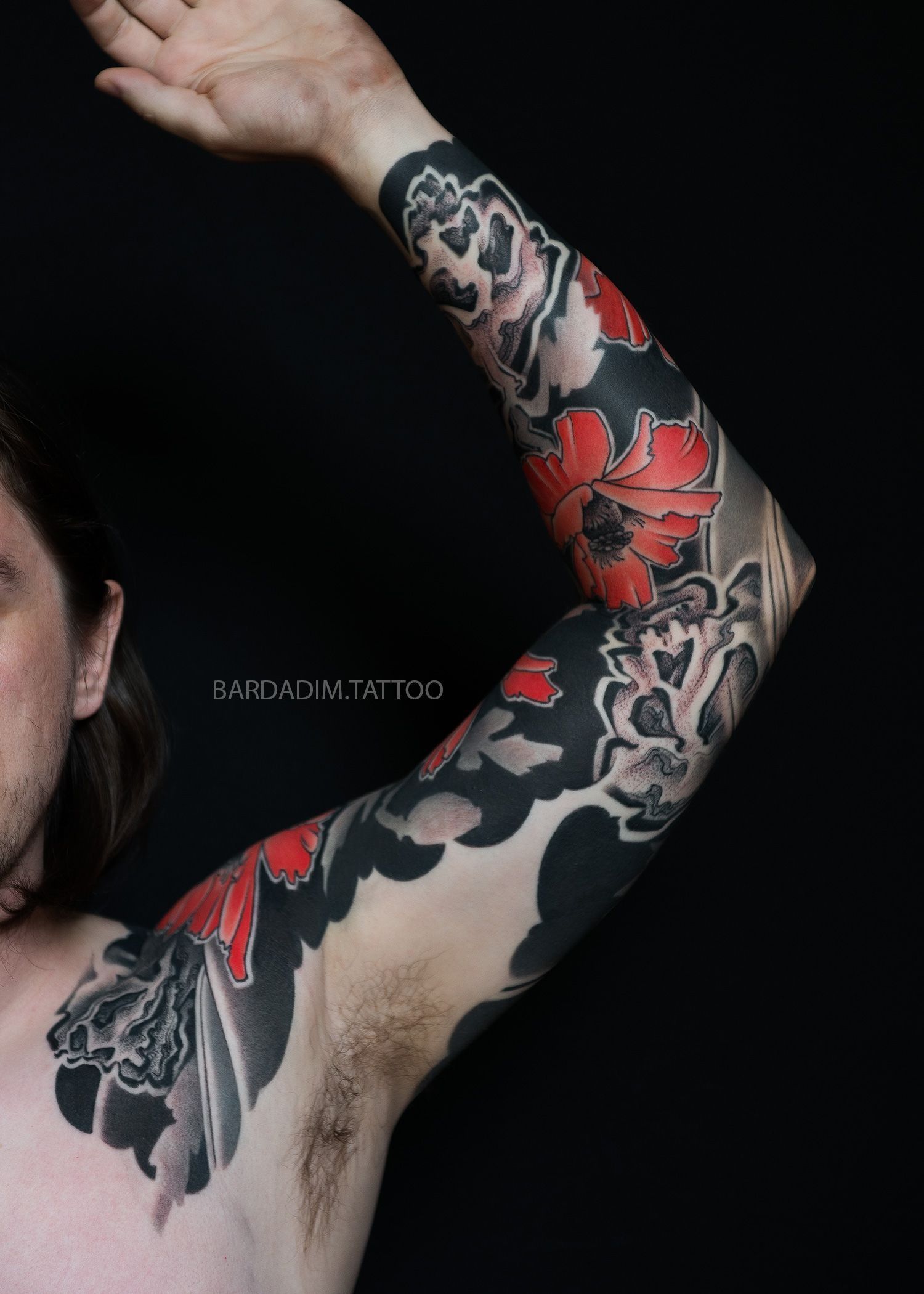 A man with a black and red tattoo on his arm