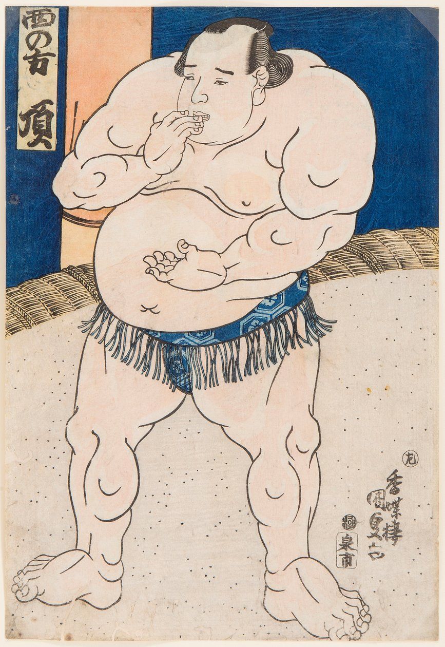 A sumo wrestler with a large build, in a blue mawashi, stands in a simple setting, holding a hand to his mouth.