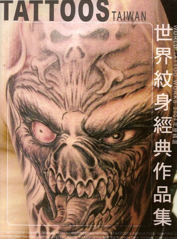 A tattoo of a skull with chinese writing on it