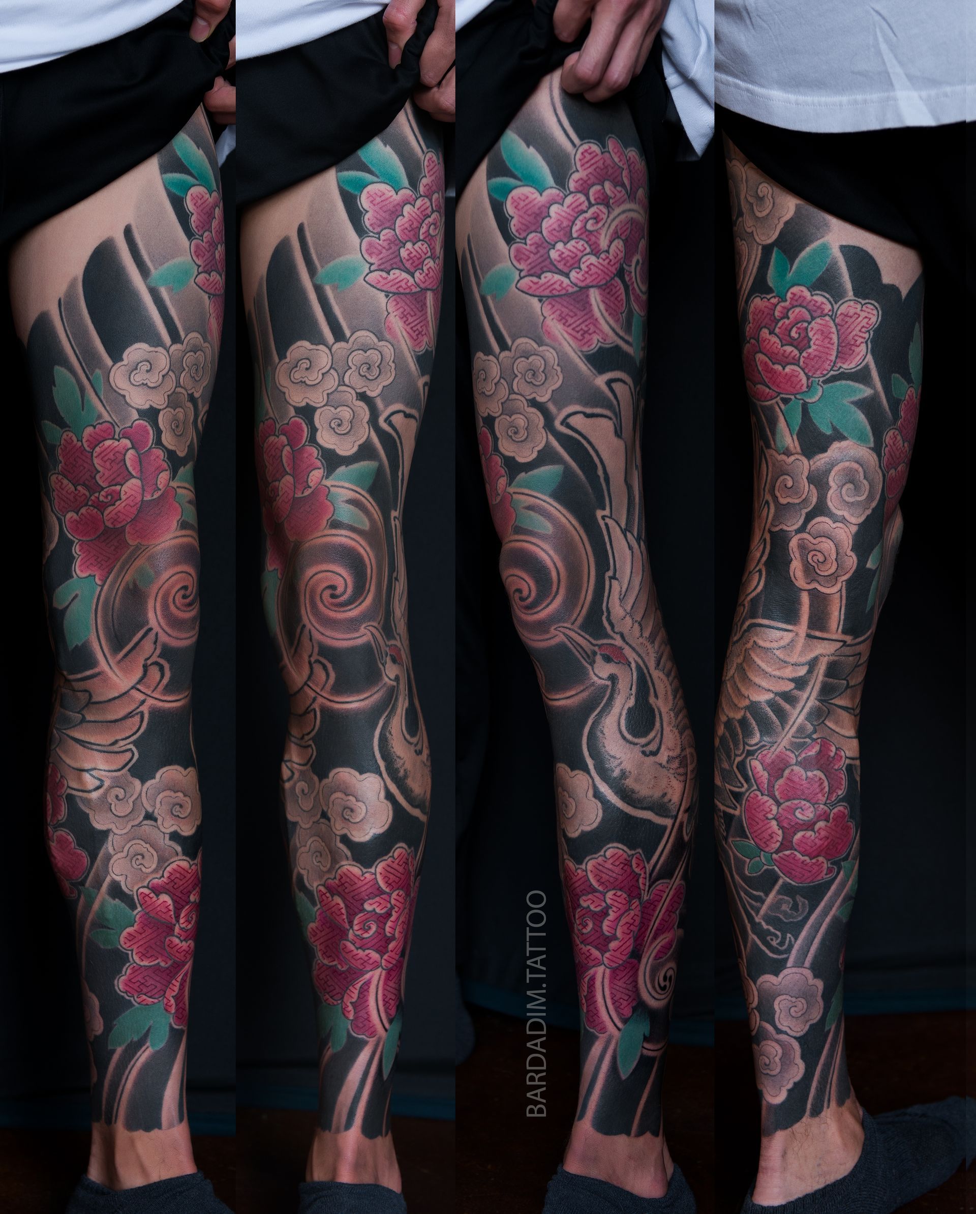 Legs with Japanese style peony flower tattoo in pink, white, and teal on a black background.