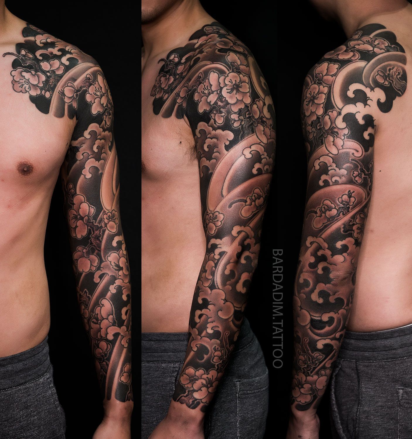 Tattooed arm with floral and wave design in black and gray ink.