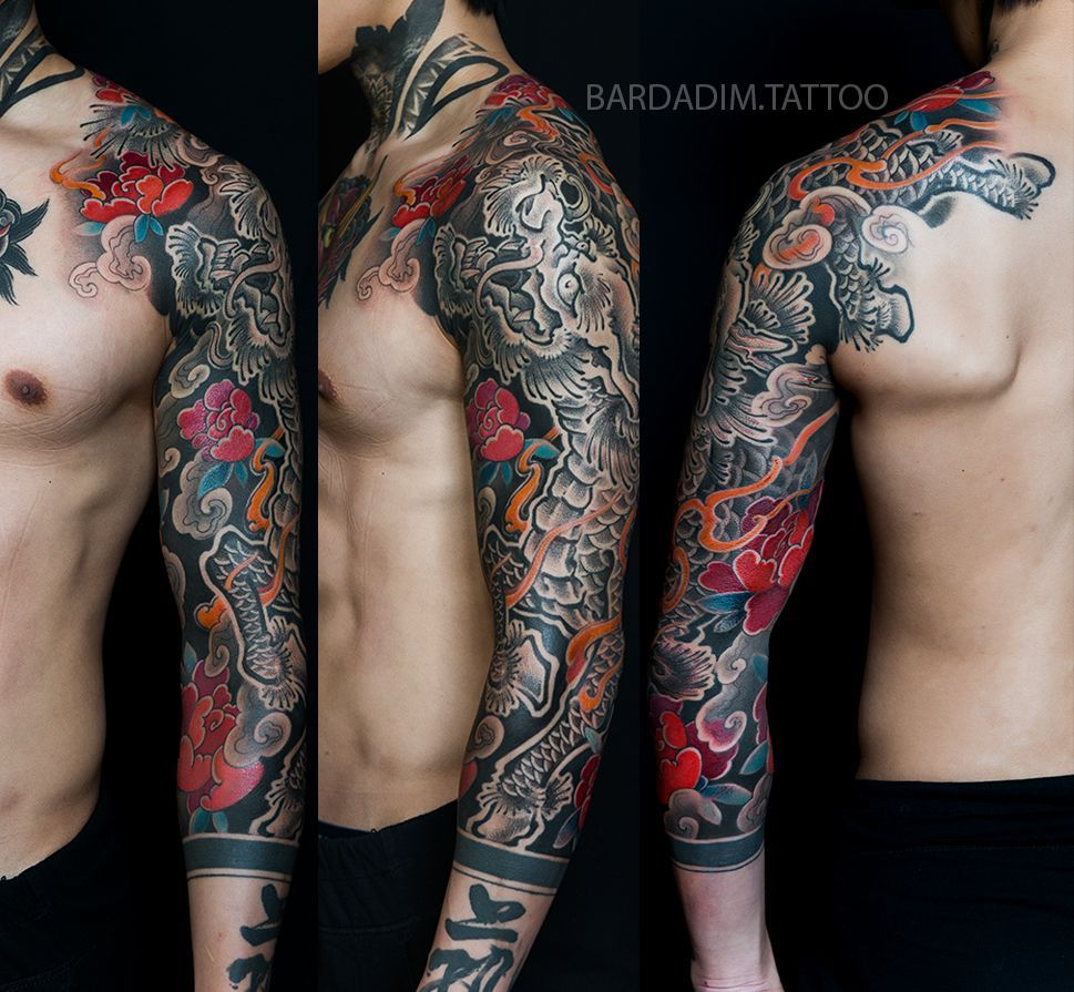 Full sleeve tattoo on a person's arm, featuring a dragon, flowers, and clouds in various colors.