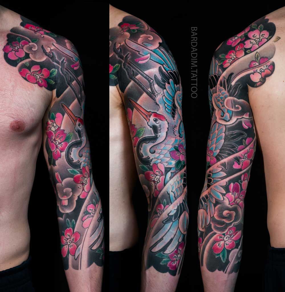 Full-arm Japanese-style tattoo featuring a crane, cherry blossoms, and dark clouds.
