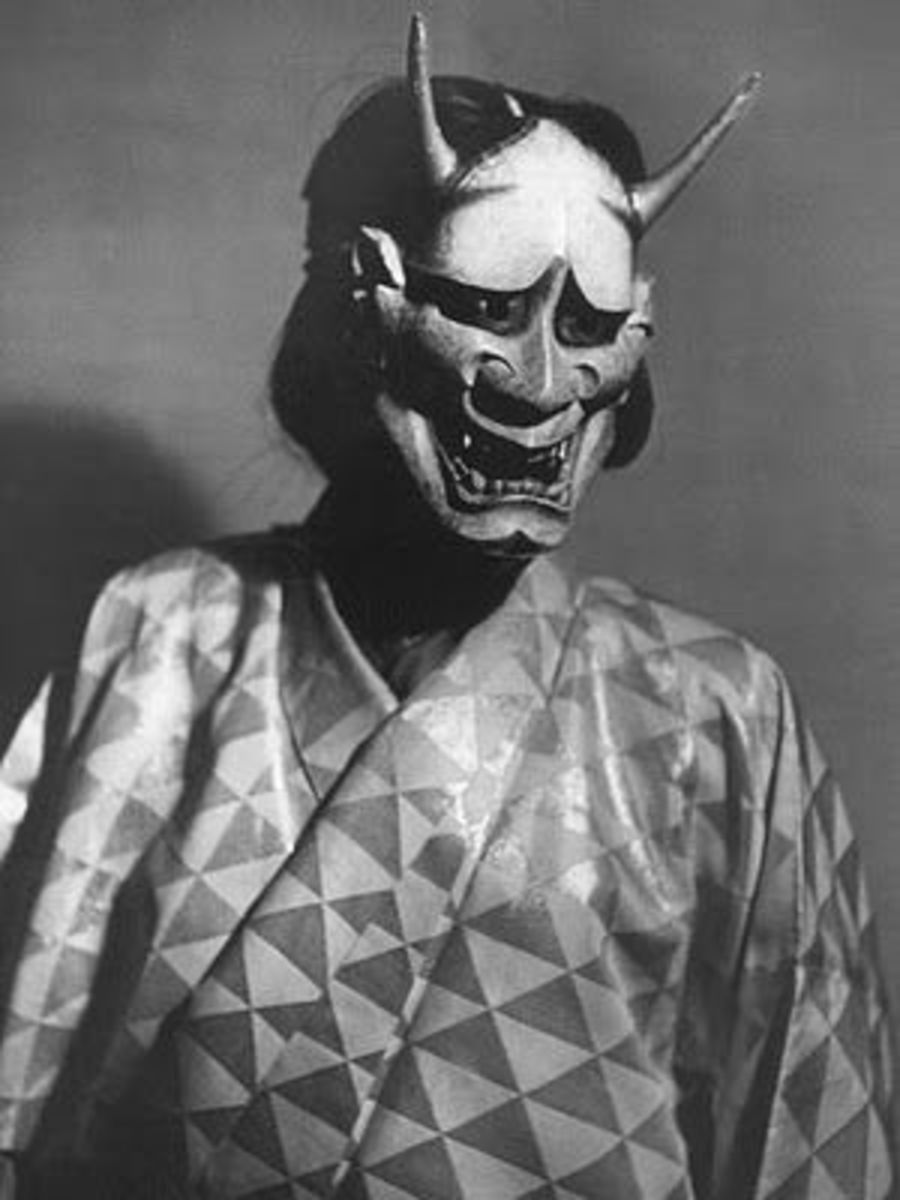 A black and white photo of a person wearing a demon mask.