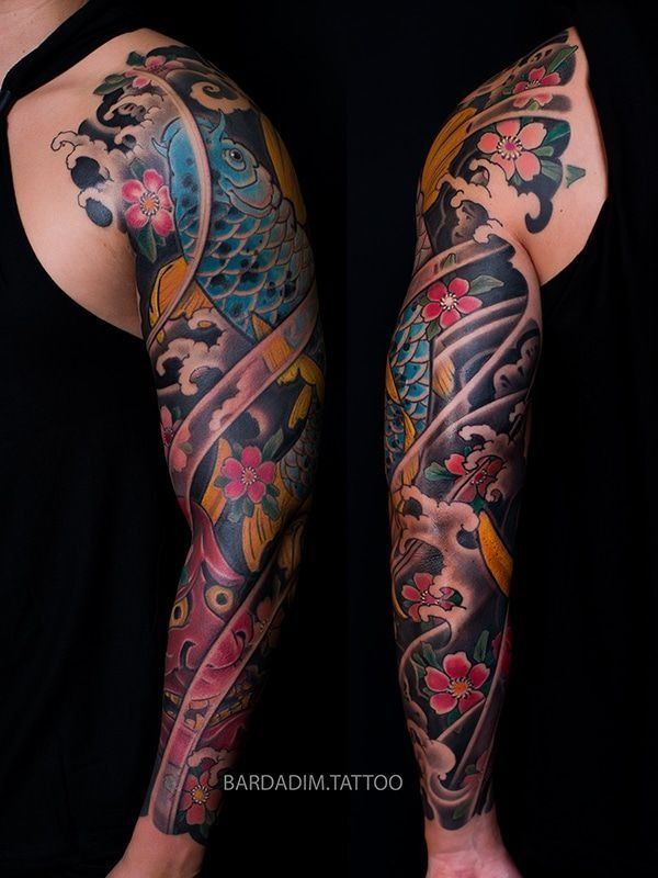 A man has a full sleeve tattoo of a fish and flowers.