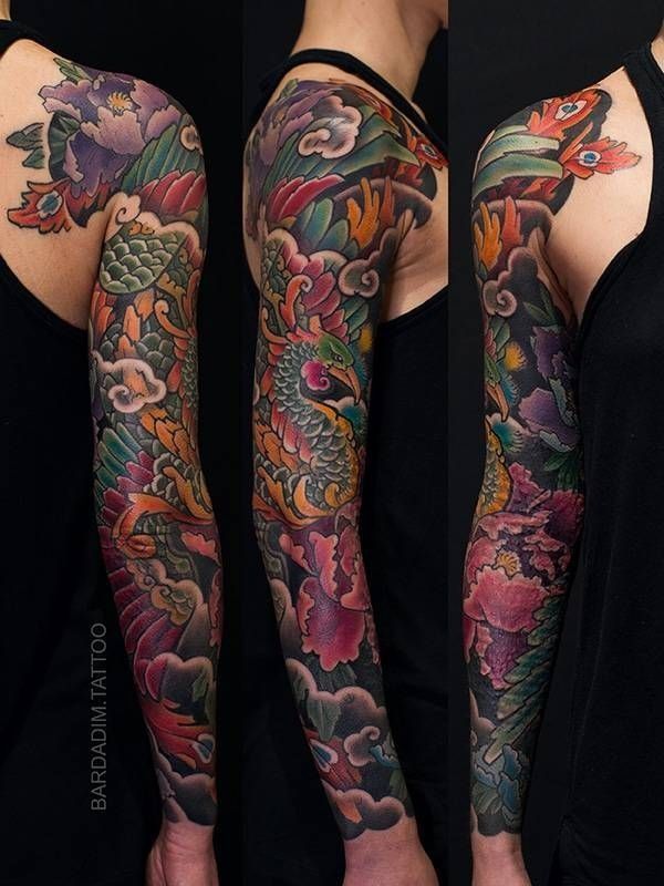 A woman has a colorful tattoo on her arm and shoulder.