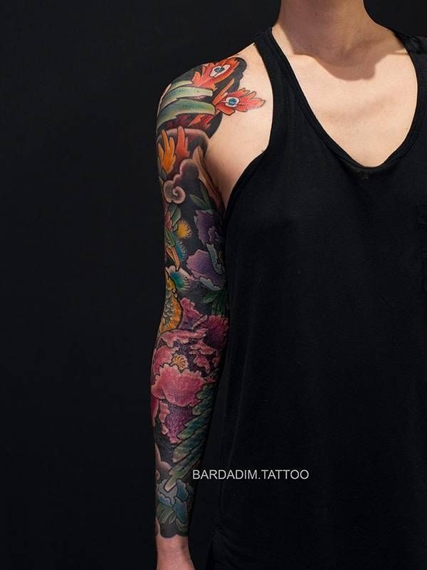 A woman has a full sleeve tattoo on her arm