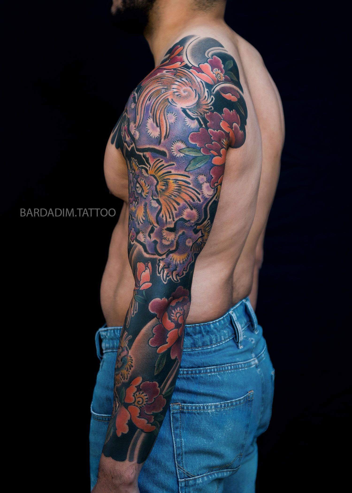 Side angle of Japanese full sleeve tattoo with Shishi Lion and peonies flowing through the arm in Gaku-bori composition by Bardadim.