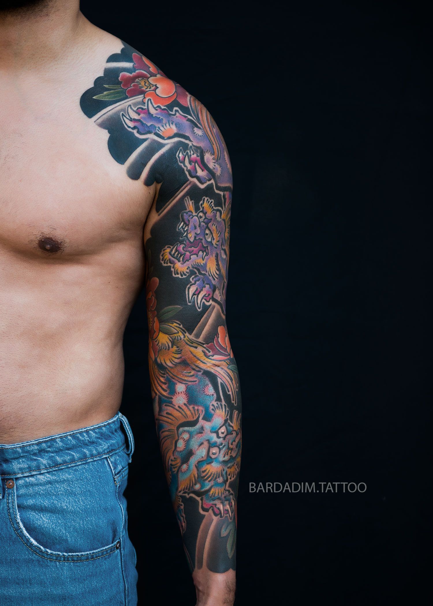 Shishi Lion surrounded by detailed peonies in a Japanese sleeve tattoo created by Bardadim Tattoo.