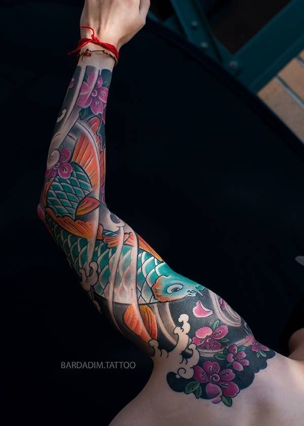 Japanese sleeve tattoo showing anatomical flow — koi and waves following natural muscle lines
