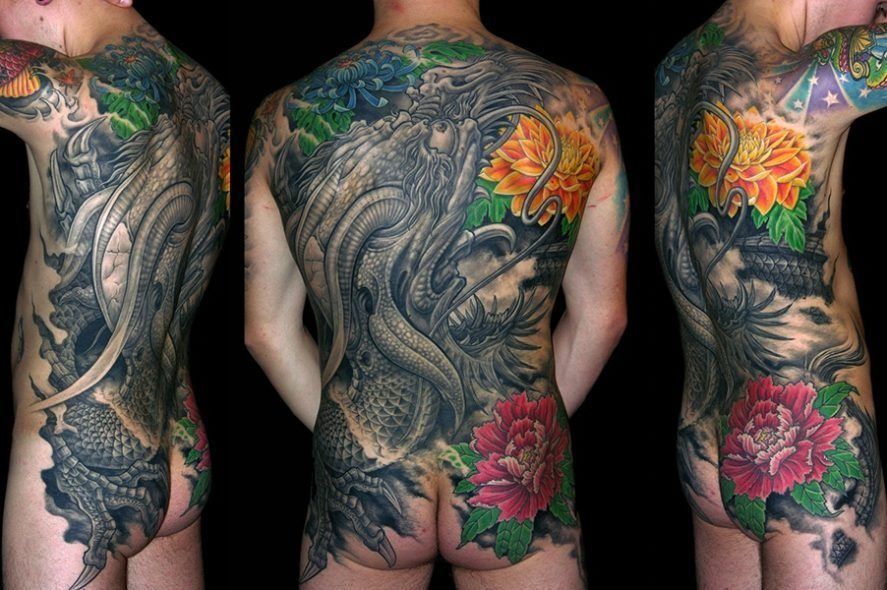 Full back tattoo with intricate dragon, flowers, and foliage, black background. Irezumi at Bardadim Tattoo
