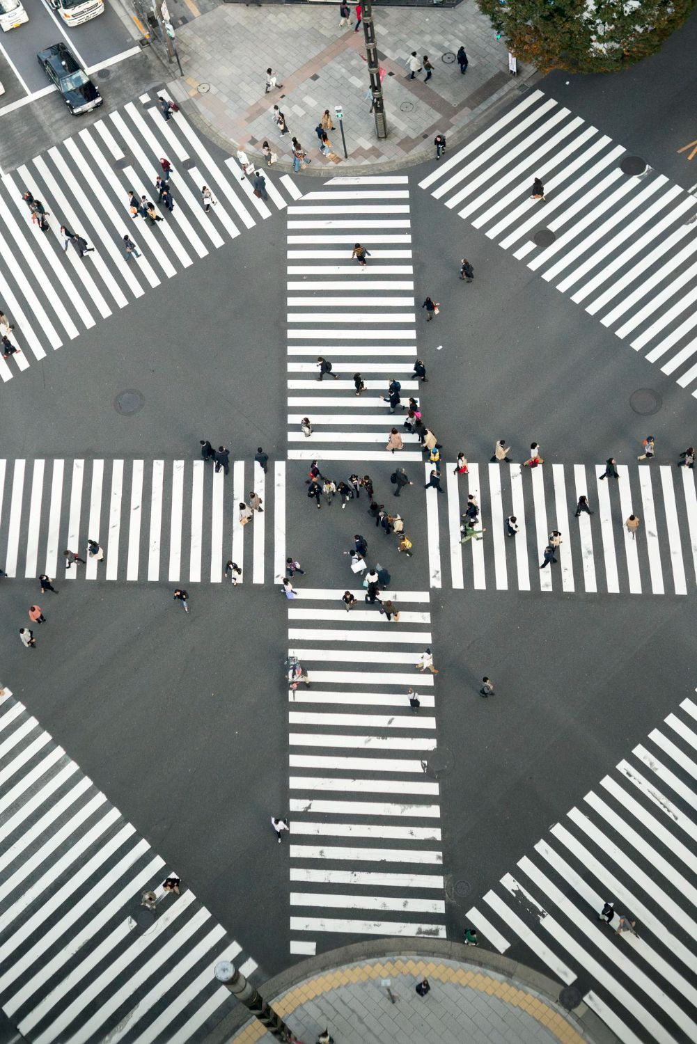 Overhead view of Shibuya crossing, a busy intersection with pedestrians using the crosswalks.