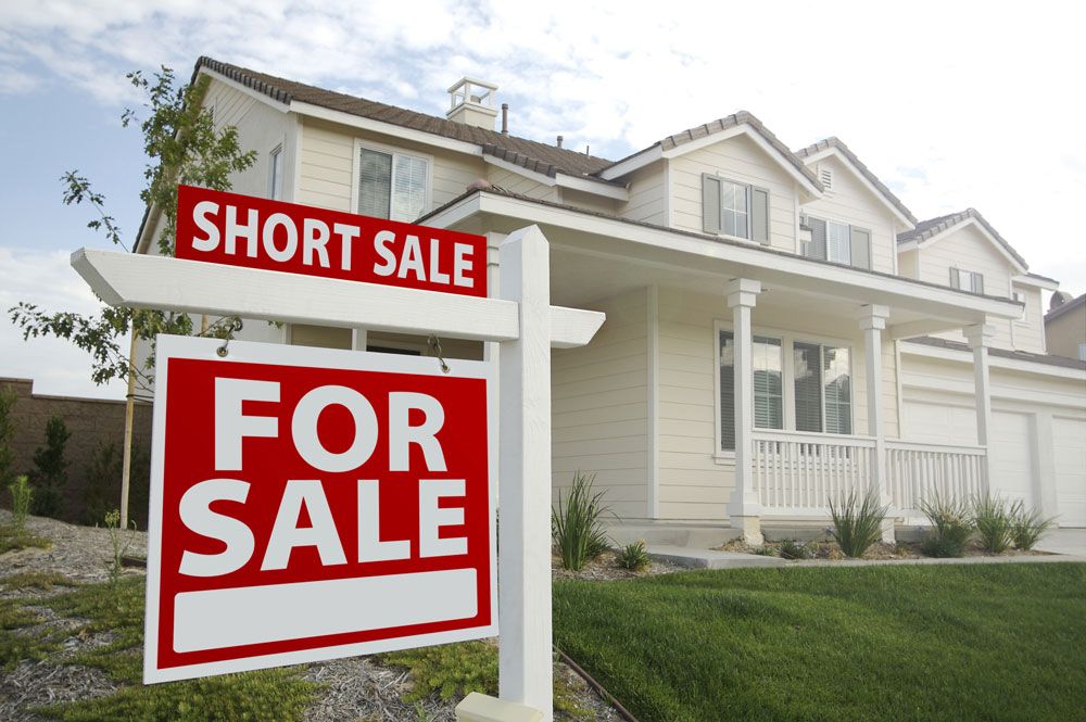 a house with a for sale sign in front of it