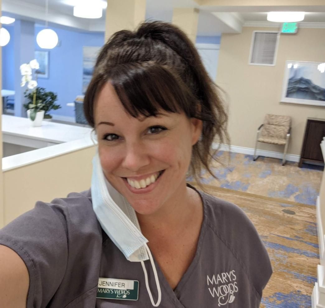 A woman wearing a scrub top that says mary 's visions