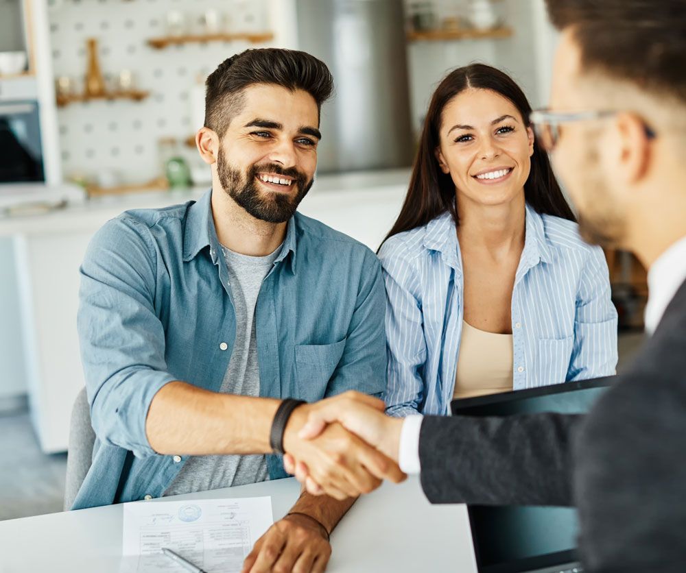 a man and woman shaking hands with a man in a suit