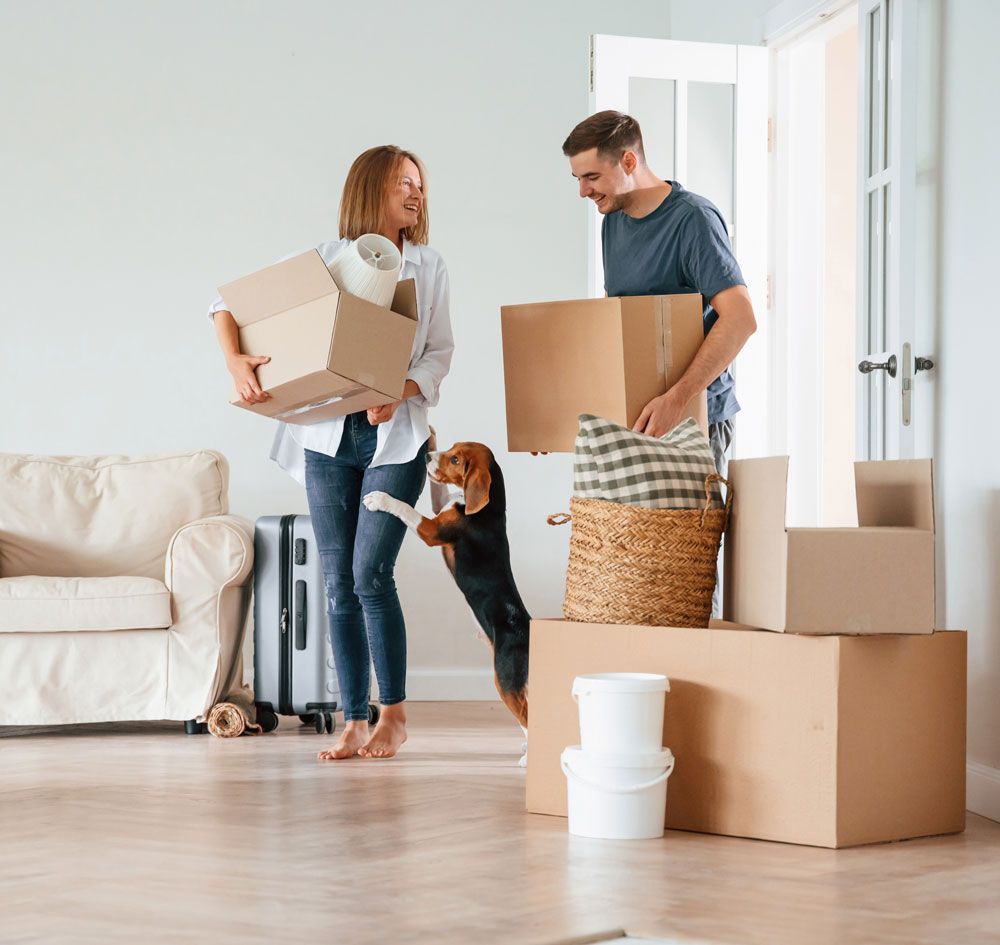 a man and woman are moving into a new home with their dog