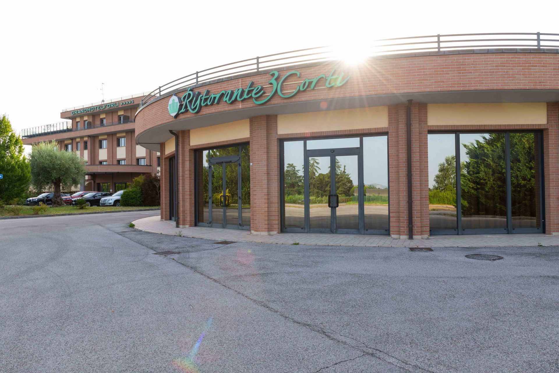 Edificio del ristorante con ampie finestre e facciata in mattoni; esterno soleggiato.