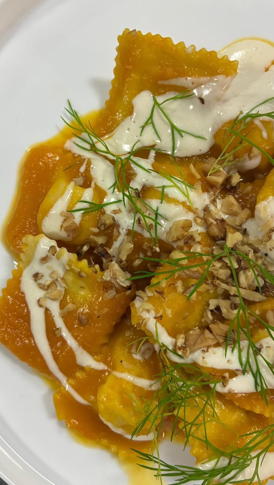 Spaghetti alle vongole su un piatto rettangolare turchese.